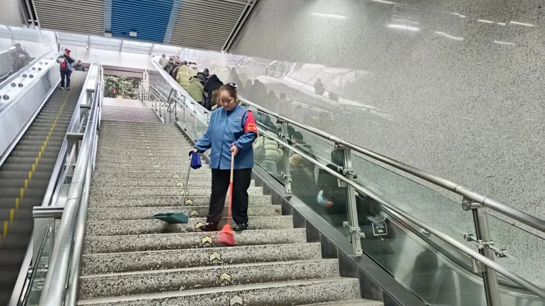 轨道5号线项目华岩中心站马菊兰员工春节在岗期间认真完成出入口楼梯垃圾清扫工作，保障春运期间的清洁服务品质.jpg