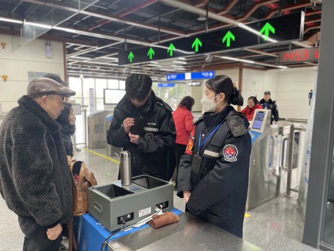 交通资源开发公司通邑公司璧铜线项目部龙城天街站点安检员王丹，正在对新进安检人员进行实践教导，保障春节期间车站运营安全有序。.jpg