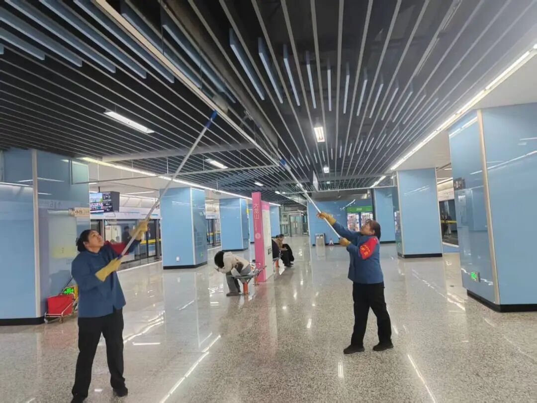 交通资源开发公司通邑公司轨道6号线项目部大龙山站保洁班组对站台挡烟垂壁开展精细化清洁作业，全面清除积尘污渍，以干净整洁的站区环境，为广大乘客营造舒适、舒心的出行氛围。.jpg